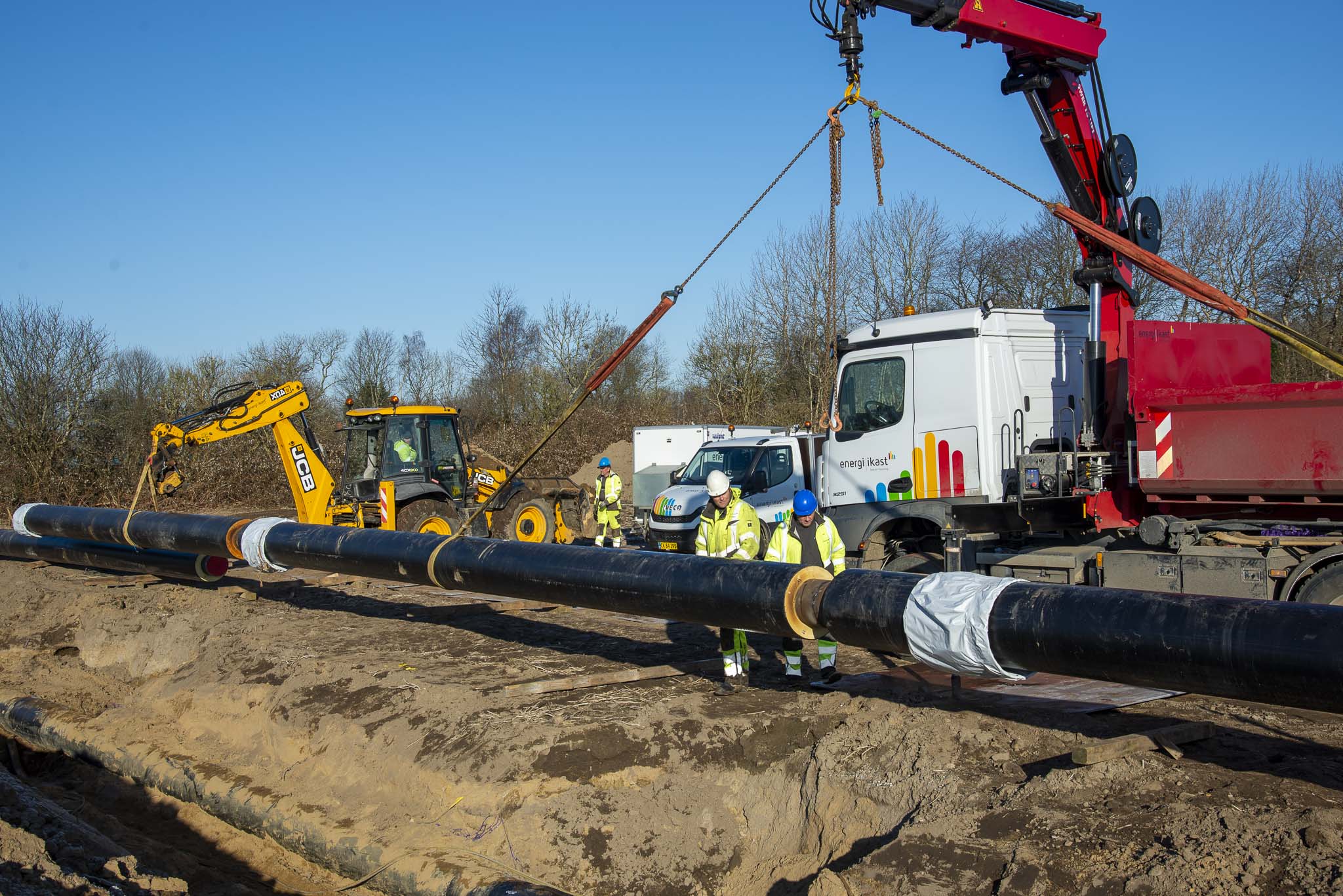 Både kran og rendegraver var i arbejde, da det store fjernvarmerør skulle løftes på plads. Foto: Rune Kaldau